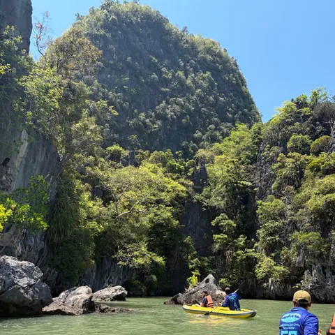Kayakers paddling below the limestone cliffs