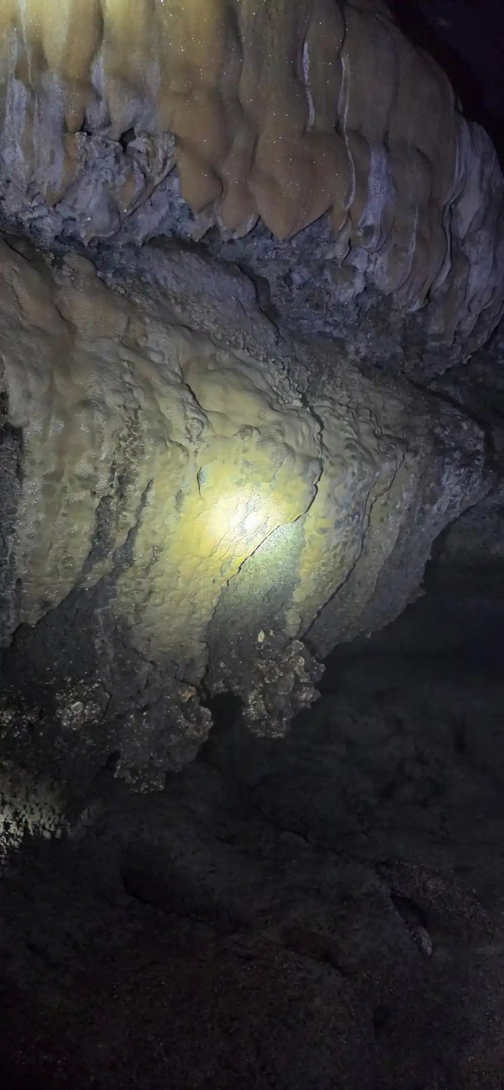 Cave interior with stalactites and yellow lighting