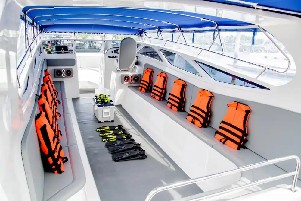 Interior of speedboat with orange life jackets and safety equipment
