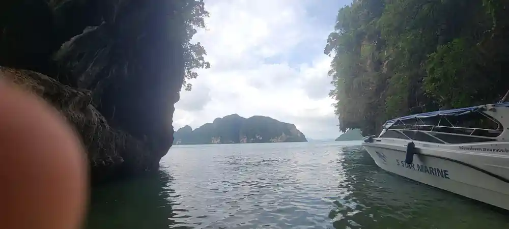 Limestone cliffs and boat moored in tropical bay