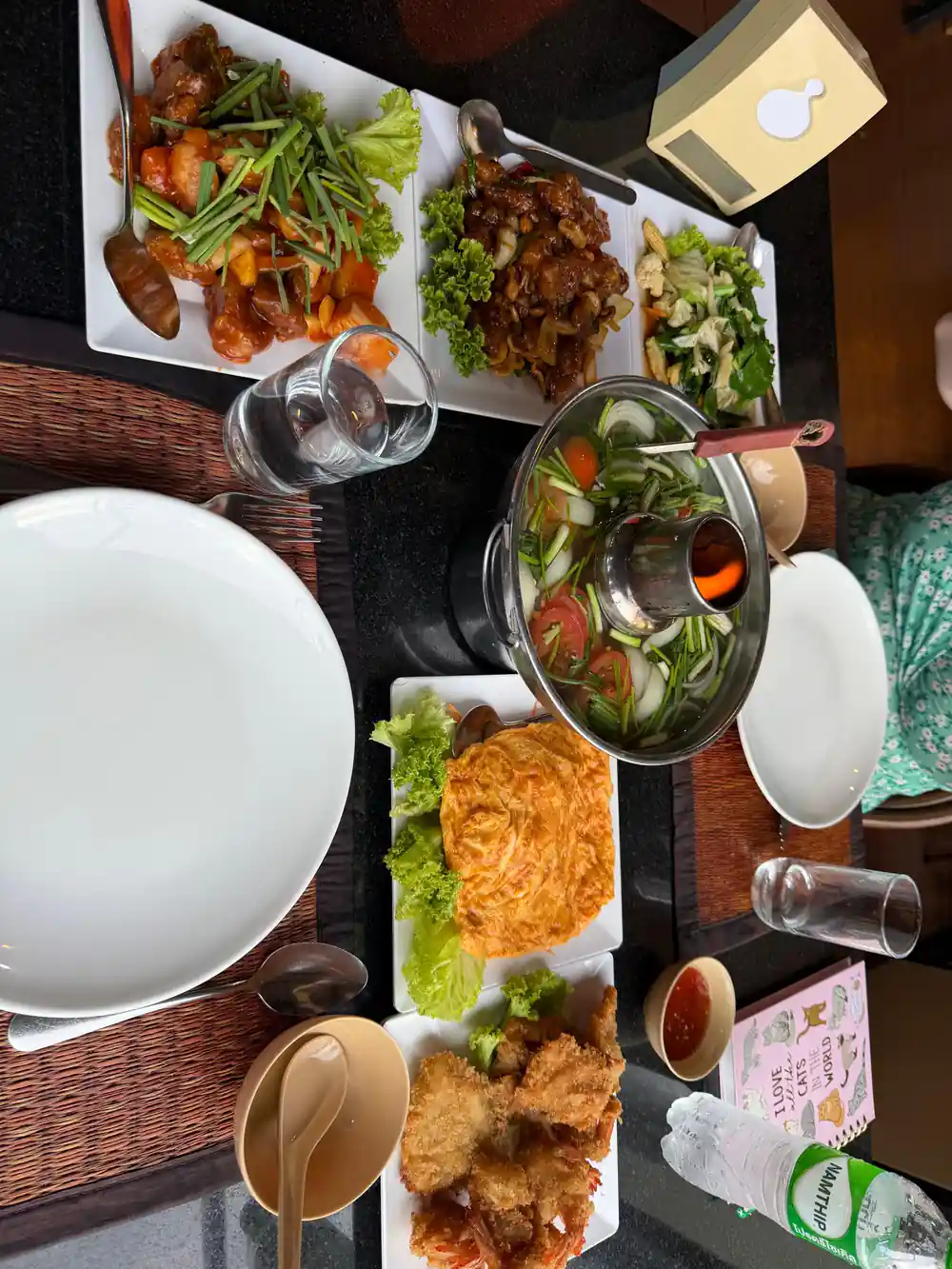 Multiple Asian dishes with rice and sauce on wooden table