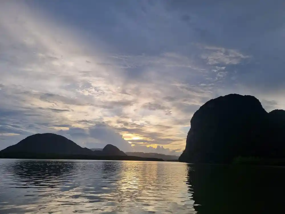 Rocky islands silhouetted at sunset over water