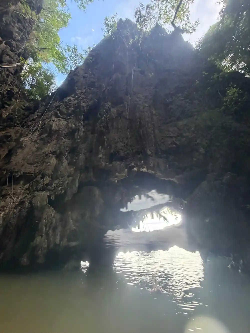 Tall limestone mountain with Buddhist temple and floating houses