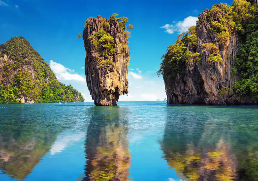 Tall limestone rock formation rising from turquoise water
