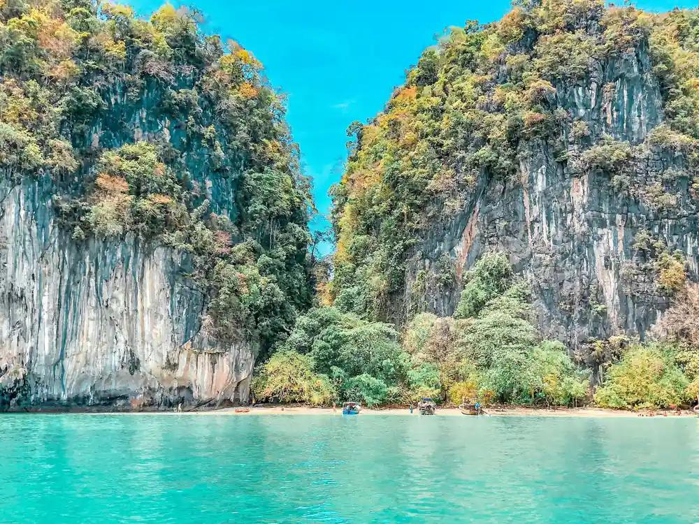 Towering limestone cliffs with vegetation flanking turquoise lagoon
